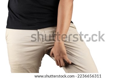 Asian man in reaction of scratching crotch on grey background, closeup. Annoying itch or Tinea Cruris. Human body problem or healthcare and medicine concept. Royalty-Free Stock Photo #2236656311