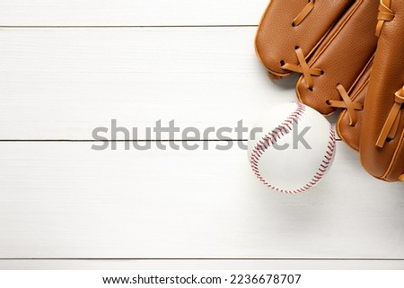 Catcher's mitt and baseball ball on white wooden table, top view with space for text. Sports game