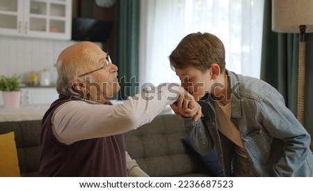A child kissing his grandfather's hands during the feast (Ramadan or Şeker Bayram). People who adhere to Muslim traditions. The child kisses his grandfather's hand, celebrates Eid or Father's Day, Royalty-Free Stock Photo #2236687523