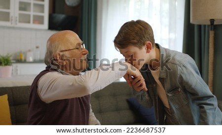 A child kissing his grandfather's hands during the feast (Ramadan or Şeker Bayram). People who adhere to Muslim traditions. The child kisses his grandfather's hand, celebrates Eid or Father's Day, Royalty-Free Stock Photo #2236687537