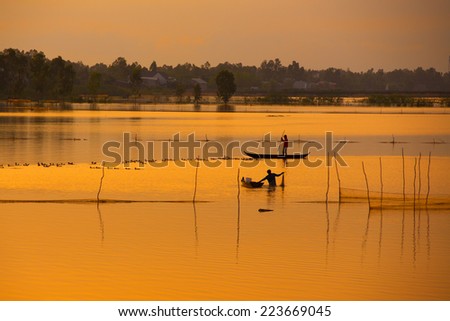 Fisher on boat in water season in sunrise in Dong Thap, Vietnam