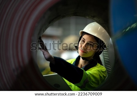 Portrait of a heavy equipment female engineer from a huge industry who came to inspect the metal sheet factory's machinery. Royalty-Free Stock Photo #2236709009