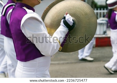 Asian students perform cymbals in the school marching band during the annual sports day. Soft and selective focus.                                Royalty-Free Stock Photo #2236725477