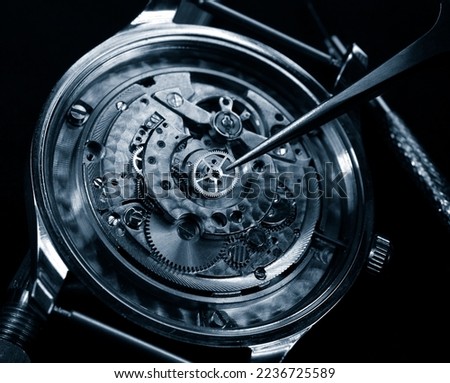 watchmaker reparaing vintage watch mechanism close up detail 