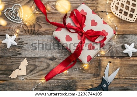 Valentine's Day gift on wooden background, top view, gift wrapping concept.