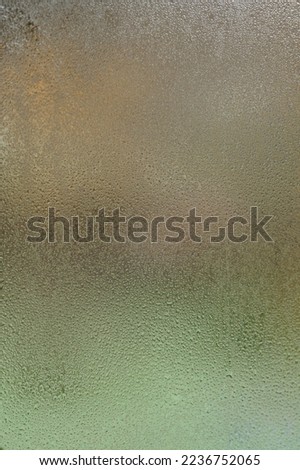 Glass and condensation on it, cooling outside and consequences in poorly heated houses, texture of condensation on the window.