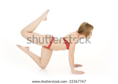 Caucasian teenager practicing yoga in a red bikini on a white background