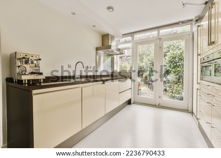 a modern kitchen with white cabinets and black counter tops in an open doord area that leads to the patio