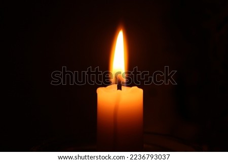 One candle on a dark background