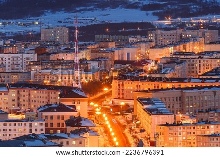 Evening cityscape with TV tower and many buildings. Top view of the city with bright street lighting at dusk. Magadan city, Magadan Region, Siberia, Far East of Russia. Royalty-Free Stock Photo #2236796391