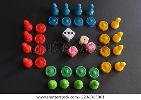 red, blue, yellow and green pieces and tokens in a row on a black background