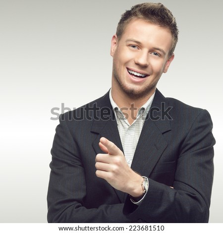 successful young businessman standing over gray background