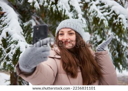 A smiling girl takes a selfie in winter.