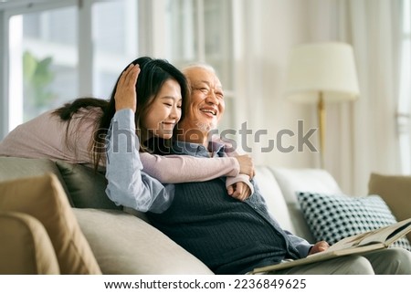 asian adult daughter and senior father enjoying conversation and good time at home Royalty-Free Stock Photo #2236849625