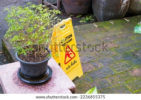 Sign showing warning of caution wet floor in rainy season.
