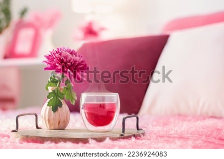 red tea in thermo glass with flowers in modern bedroom in trendy color of year 2023 Royalty-Free Stock Photo #2236924083