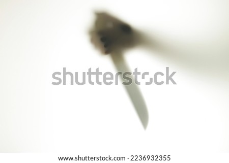 Blurred Shadow figure with a knife behind glass. Concept of serial killer, domestic violence Royalty-Free Stock Photo #2236932355