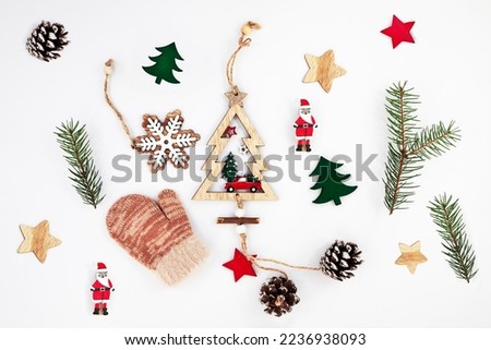 Christmas wooden decorations and natural spruce branches on a white background. Flat styling, festive composition.