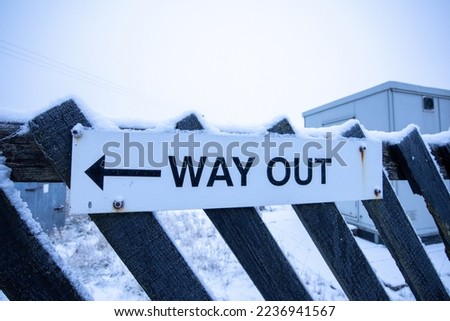 Way out sign covered in snow at Ribblehead train station in the Yorkshire Dales. 
