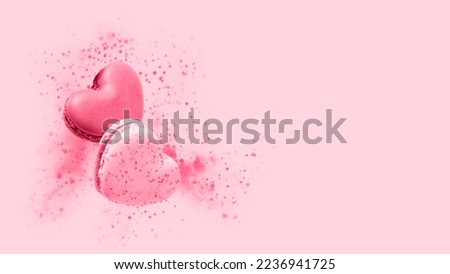 Two sweet macarons in heart shape flying isolated on pink background. Monochrome image with french macaron cookies toned in trendy color 2023 Viva Magenta. Romantic love or pastry shop card  Royalty-Free Stock Photo #2236941725