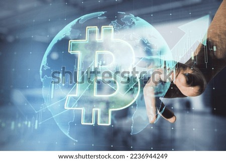 Close up of hand pointing at growing global bitcoin hologram on blurry office interior background. Cryptocurrency, market growth and stock exchange concept. Double exposure