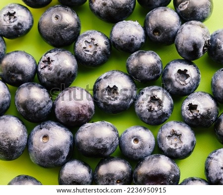 Natural looking blueberries on green background. Top view. Selective focus in the middle.