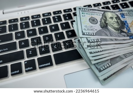 First person top view photo of money hundred dollar bills on white keyboard. quick money work online. Side job