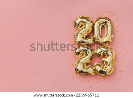 Happy New Year 2023 greeting card. 2023 golden foil balloons numbers and confetti. Top horizontal view copy space new year and christmas holiday concept.