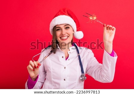 A cheerful nurse in a white coat with sparklers on a red background. Merry Christmas Greetings