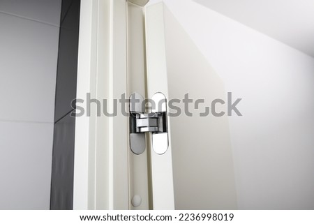 New modern metal door hinges hidden on white wooden doors. Royalty-Free Stock Photo #2236998019