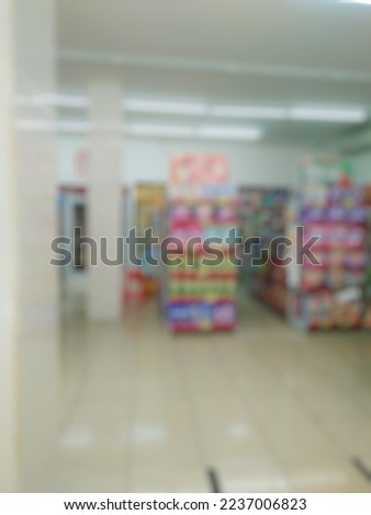 Blurred image various kinds of goods on the shelves in minimarket or Bokeh image Typical Indonesia retail store.