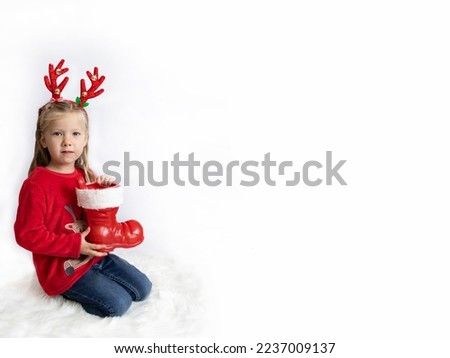 Christmas. A girl with deer horns in a red sweater holds santa boots. Banner. Concept copy space, poster, text, congratulation, invitation, holiday, template, vacation, promotion.mockup.