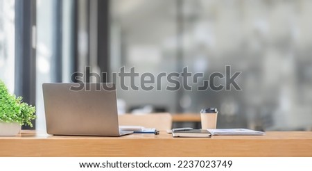 Minimal background image of inviting empty workplace laptop with white desk and succulent plant in foreground, copy space Royalty-Free Stock Photo #2237023749