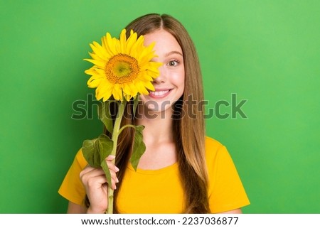 Closeup photo of funky cute schoolgirl teen age toothy beaming smile hold yellow blossom sun flower enjoy summer isolated on green color background