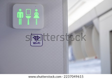 Green sign of lavatory in the airplane during fly. A Vacant of toilet indication of modern aircraft. Jet plane information restroom label. Royalty-Free Stock Photo #2237049615