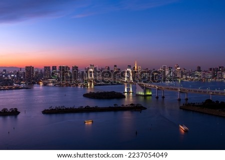 Panoramic view of Tokyo cityscape at dusk with Rainbow bridge and Tokyo tower.