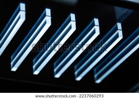 Closeup of modern long strip glass lamps on the ceiling