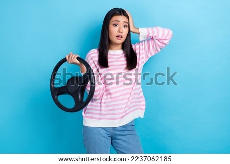 Photo of young confused nervous stressed japanese woman wear striped pink sweater hold steering wheel touch head isolated on blue color background