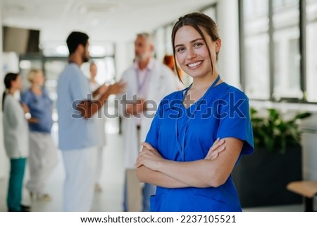 Portrait of young woman nurse at hospital corridor. Royalty-Free Stock Photo #2237105521