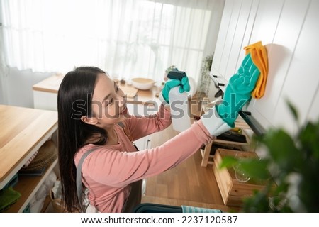 Happy Asian young woman sweeping sofa and furniture to cleaning house, healthy lifestyle concept Royalty-Free Stock Photo #2237120587