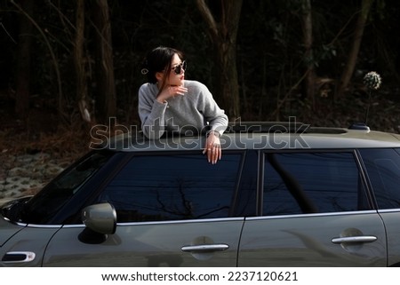Asian woman lying on the roof wearing black sunglasses