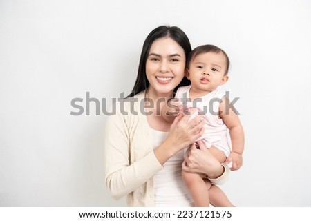 Beautiful mother and adorable baby girl are happy on white background, family, child, childhood and parenthood concept 