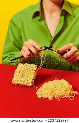 Creative image with woman knitting instant noodles on blue table on vivid red tablecloth over yellow background. Food pop art photography. Complementary colors. Copy space for ad, text
