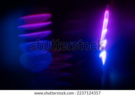 Blurred Light painting one exposure in camera. light glares with a spectral gradient on a dark background. Multicolored abstract colorful line. Unusual light effect.