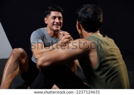 young athletic men meeting in the gym and shaking hands after workout Royalty-Free Stock Photo #2237124631