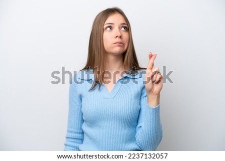 Young Lithuanian woman isolated on white background with fingers crossing and wishing the best