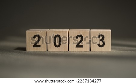 woodblocks cubes square with number 2023 on wood table. business goals next year. new year 2023 concept.