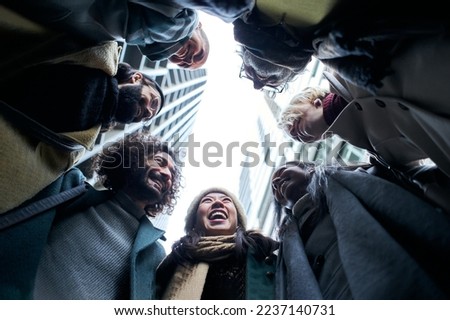 Low angle of a unity group of business people in circle. Happy smiling colleague co-workers. Community of diverse aged and multiracial teamwork. Cheerful teamwork in winter clothes. High quality photo Royalty-Free Stock Photo #2237140731