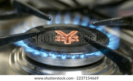 Gas burner and yuan sign, symbol of Chinese money on a domestic gas burner. Concept of energy crisis.Selective focus