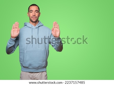 Serious young man making a gesture of stop with his palm
